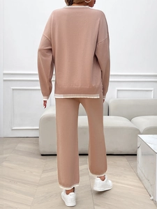 Detail of khaki knit set featuring white stripe accents on long sleeve hem and pants