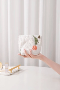 Detail of tulip embroidery on white jacquard cosmetic bag with flower zipper pull