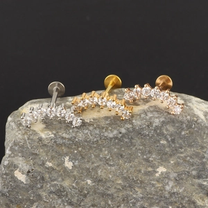 Detailed view of three curved zircon labret studs in silver, gold, and rose gold finishes