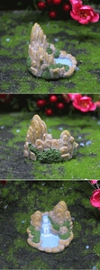 Macro view of artificial rockery bonsai with green moss and miniature water stream details