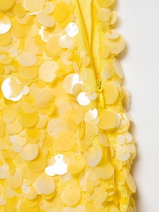 Gros plan de paillettes jaunes et fermeture éclair invisible sur une mini-jupe ajustée
