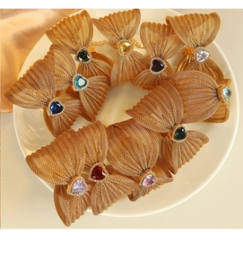 Detailed macro view of butterfly gold mesh jewelry with colorful heart-shaped gemstones