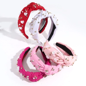 Detail view of knotted wide headbands with heart pearls and rhinestones in five colors