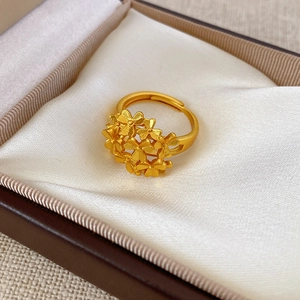 Detailed macro view of 24k gold plated flower cluster open ring on satin lining