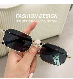 Detail of geometric polygon sunglasses with gold metal frame and dark grey lenses