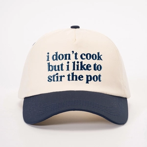 Adjustable two-tone baseball cap in cream and navy with blue 'I don't cook' embroidery