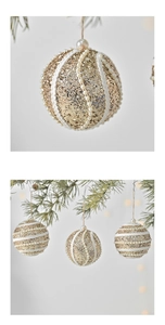 Detailed close-up of golden Christmas ball with white lace sequins and pearl bead accents