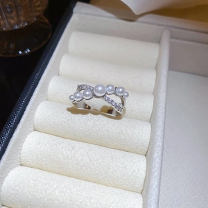 Detail van zilveren crossover ring met witte parels en kristallen in geschenkdoos