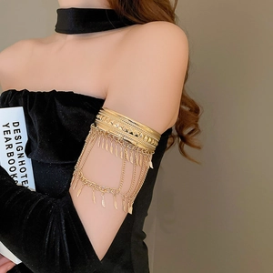 Détail d'un bracelet de bras doré bohème avec chaînes multicouches et pendentifs feuilles