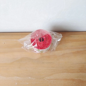 Detailaufnahme von festlichem rot-weißem Geschenkband mit Blattmuster für DIY-Verpackungen