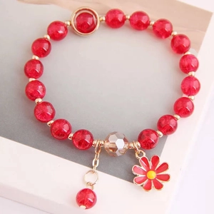 Detailed close-up of pink crackle crystal beads and daisy flower charm on elastic bracelet