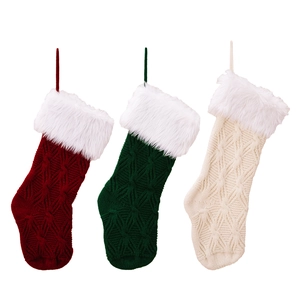 Three knitted Christmas stockings in burgundy, dark green, and cream white with hanging loops