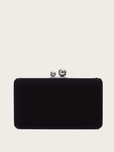 Elegant black suede evening clutch bag with silver spherical clasp on beige background