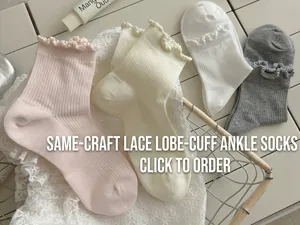Detailed close-up of white and pink hollow-out lace crew socks with ruffled cuffs