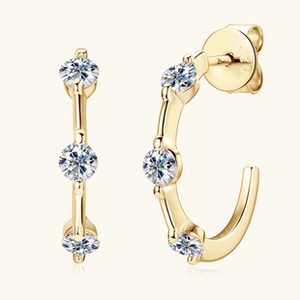 Detail view of 925 silver gold-plated C-shaped earrings with three round moissanite stones