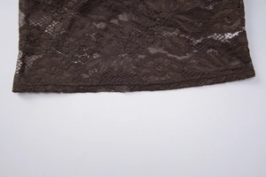 Gros plan détaillé du tissu en dentelle marron foncé avec motifs floraux ajourés