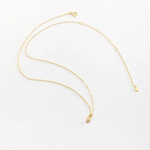 Detail view of the S925 sterling silver stamp on a gold heart lock necklace clasp