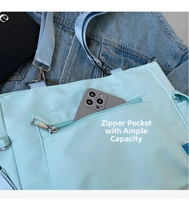 Detail of light blue Oxford tote bag featuring a practical front zipper pocket for storage