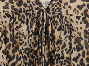 Détail d'une robe en mousseline léopard avec col en V et cordon de serrage assorti