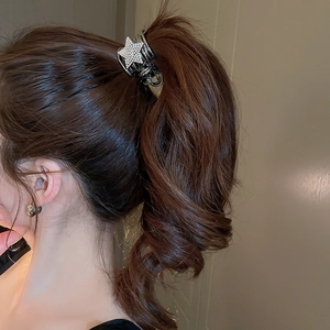 Detailed view of Y2K silver star hair claw with rhinestones on a high ponytail
