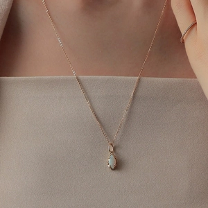 Close-up of elegant marquise-cut opal pendant necklace on rose gold s925 silver chain