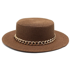 Detail of dark brown straw hat with a bold gold chain and fine woven texture