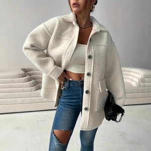 Detail of white faux fur jacket featuring large front pockets and round dark buttons