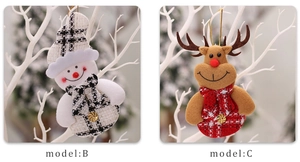 Detail of Christmas snowman and reindeer plush ornaments hanging on white branches