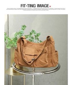 Detail showing multiple functional pockets and durable brown canvas texture of messenger bag
