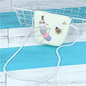 Close-up of kids straw crossbody bag with colorful caterpillar and flower patches
