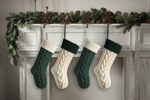 Close-up of four cable knit Christmas stockings hanging on a white festive fireplace mantle