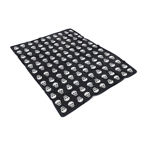 Close-up of soft black flannel blanket featuring a repeating white skull pattern