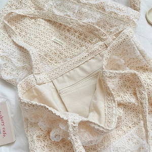 Detail of hollow lace crochet tote bag featuring inner canvas lining and zipper pocket