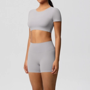 Seitenansicht des hellgrauen Yoga-Sets mit kurzem Oberteil und High-Waist-Biker-Shorts