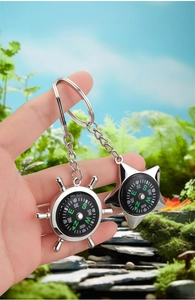 Detail of zinc alloy compass keychains in steering wheel and star shapes with clear scales