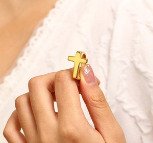 Minimalist 18k gold cross ring for women with a polished finish worn on a finger