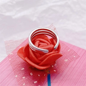 Close-up of triple-layered silver open toe ring resting on a red rose flower petal