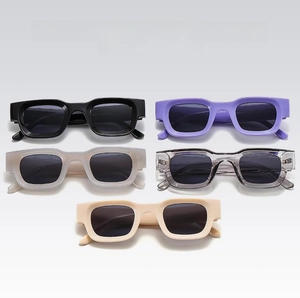 Row of five colorful retro rectangular sunglasses in black, purple, grey, and cream