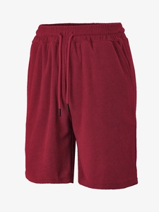 Detail of burgundy waffle knit fabric texture and elastic drawstring waistband on men's shorts