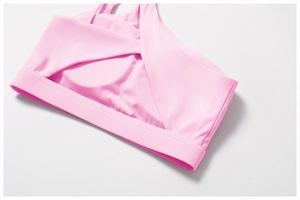 Detail of pink sports bra featuring cross-over overlap front and wide elastic underband