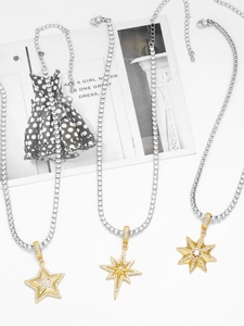 Detailed view of gold and silver star pendants with zircon inlay on a tennis chain