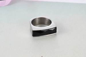 Close-up of minimalist stainless steel ring featuring a black rectangular gemstone inlay