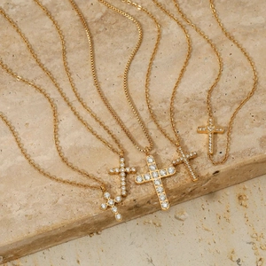 Gold stainless steel cross pendants with zircon stones on natural travertine stone
