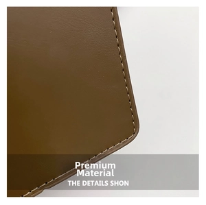 Detail shot of premium brown leather texture with precise contrast stitching on the edge
