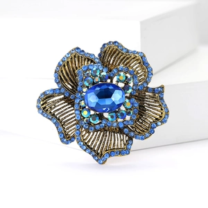 Detailed view of vintage flower brooch with royal blue crystals and gold-tone base