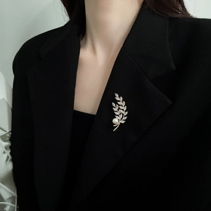 Detail of wheat ear brooch with pearls and cubic zirconia on a black suit lapel