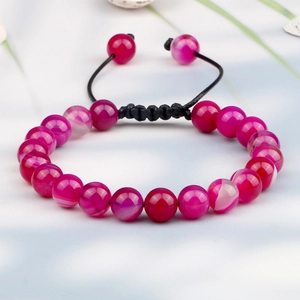Detail of magenta striped agate beads with a black adjustable woven cord bracelet
