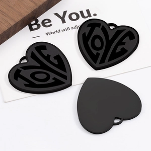 Detailed view of a matte black heart charm featuring a hollowed-out LOVE design