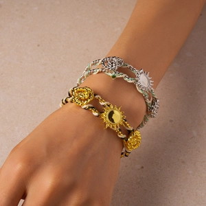 Detail of woven rope bracelets featuring metallic sun and rose charms in gold and silver