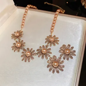 Elegant floral pearl necklace set with shimmering crystals and champagne rose gold finish